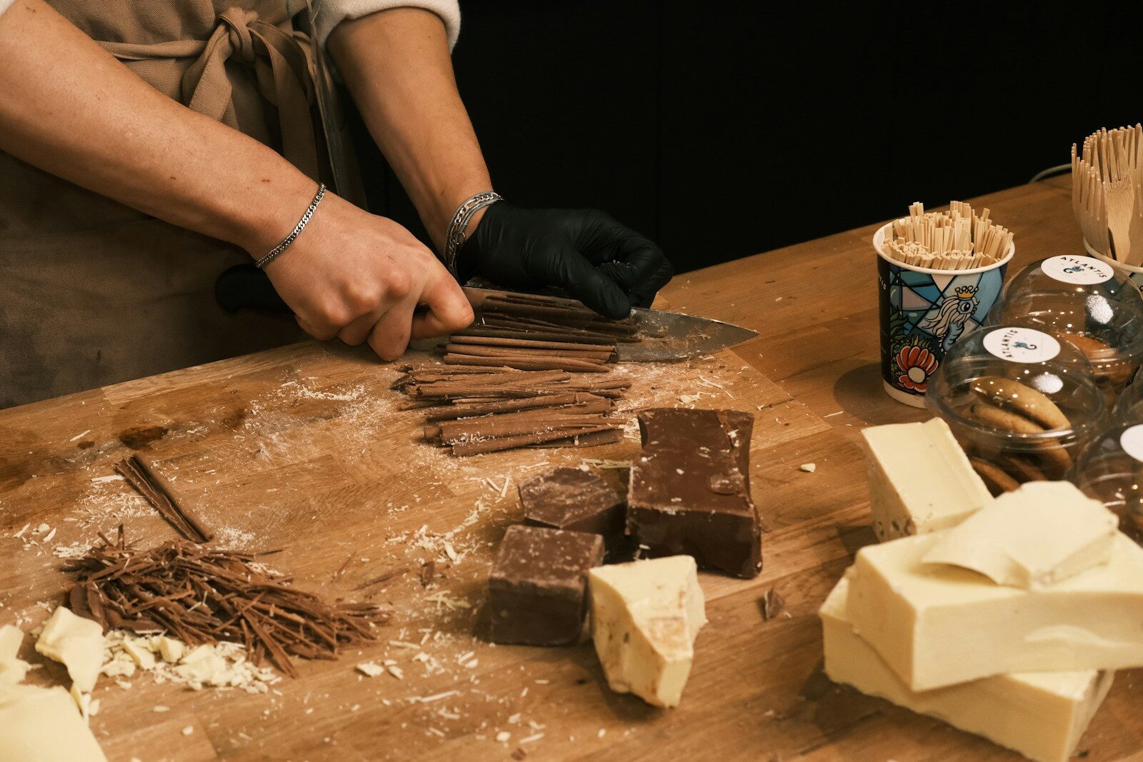 A man in an apron is making chocolates